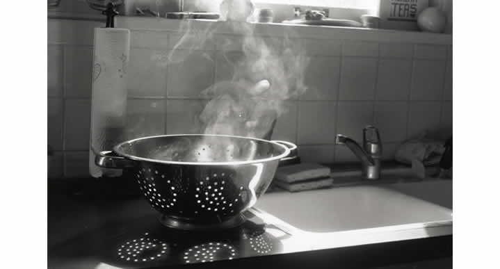 B&W image of a steaming spaghetti strainer